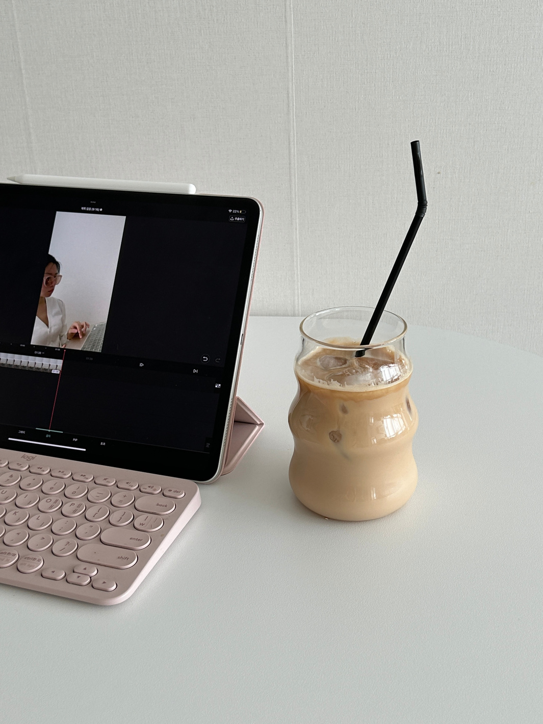 An tablet PC and a cup of iced coffee on the white table
